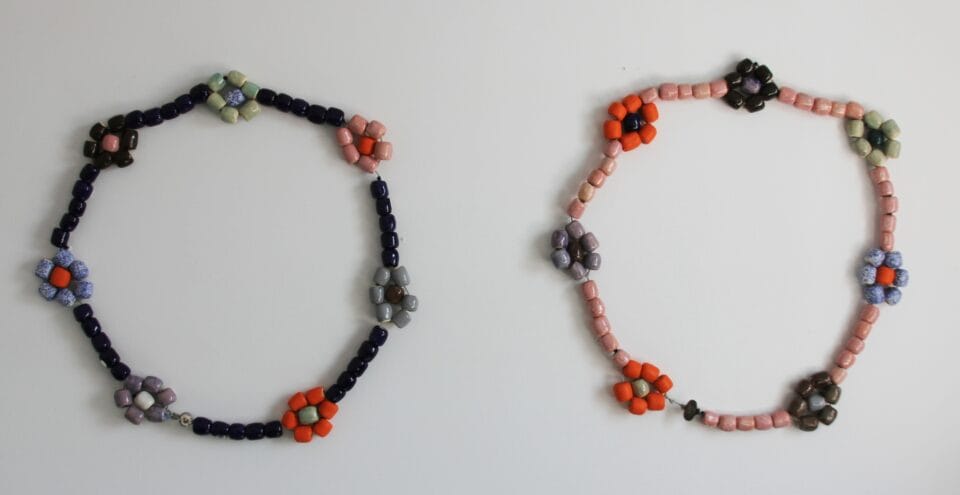 two side-by-side sculptures of charm bracelets with matching color palettes made with ceramic beads. the beads are threaded in the shape of flowers