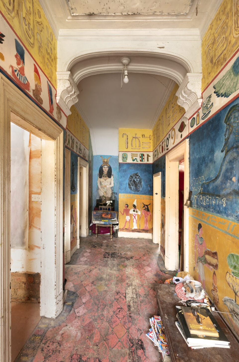 the interior of Ron Gittins' apartment in Birkenhead, England, of the hallway of the flat with painted walls reminiscent of ancient Egypt