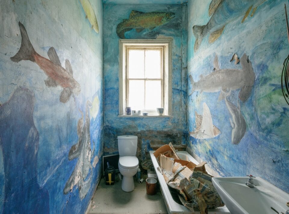 the bathroom of Ron Gittins' apartment, featuring murals of fish that cover the entire room