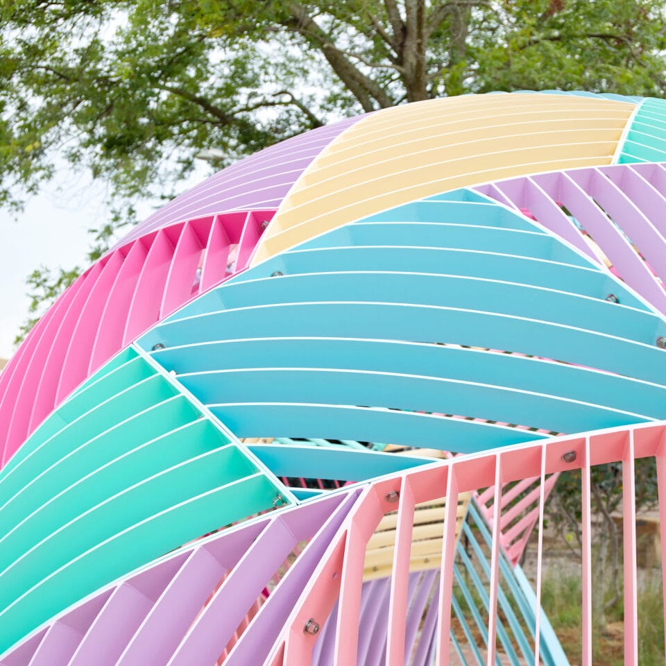 a detail of a colorful geometric outdoor dome structure made of metal with different geometric facets and openings