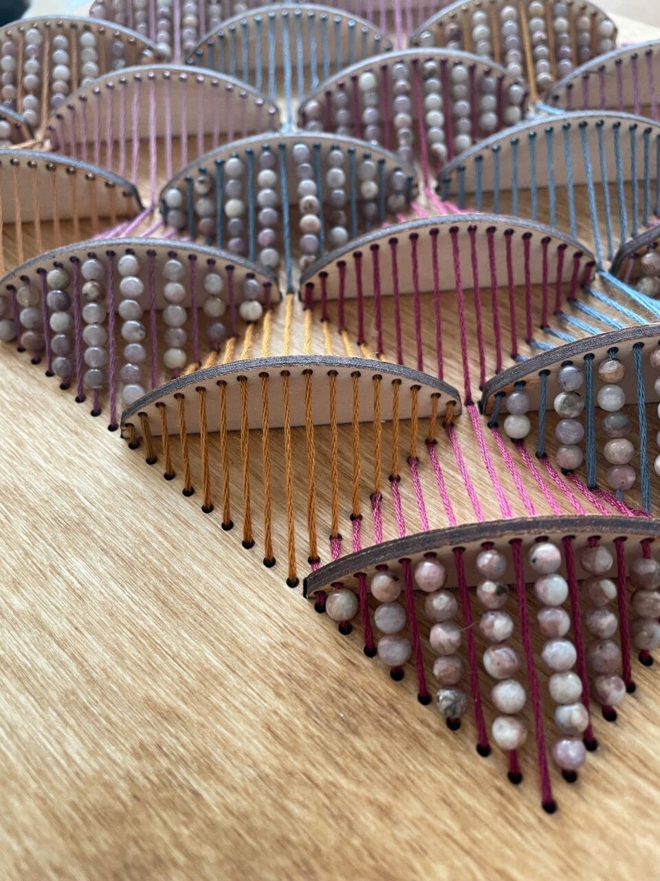 a detail image of embroidered sculptures with small wooden pieces and beads to create dimension