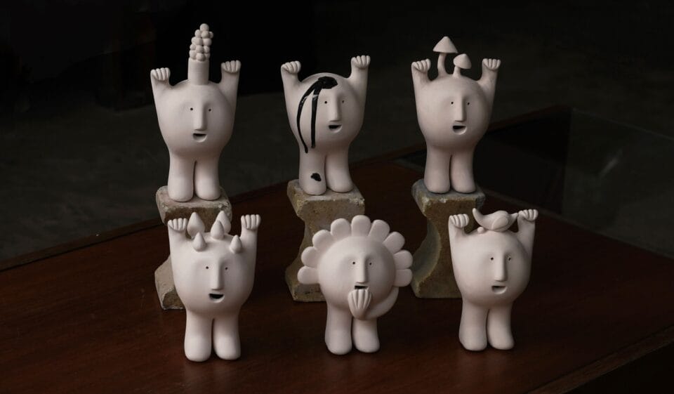 six small figurines of expressive ceramic faces with limbs. though they look similar, each dons its own unique feature