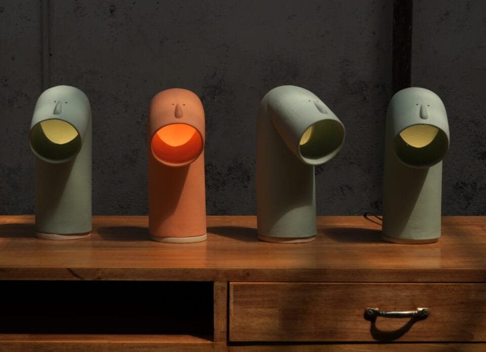 four lamps with openings that look like a creatures mouth.