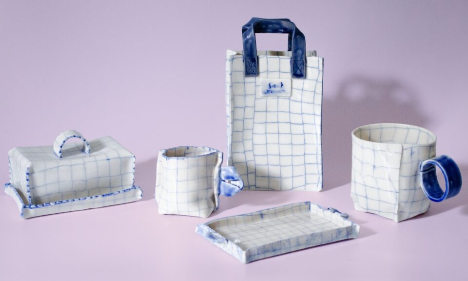 a collection of ceramic mugs, trays, and vessels that appear to be made of white graph paper