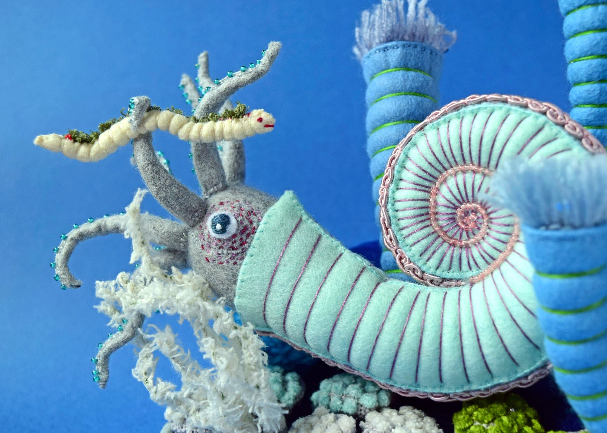 a detail of a plush blue ammonite and worm