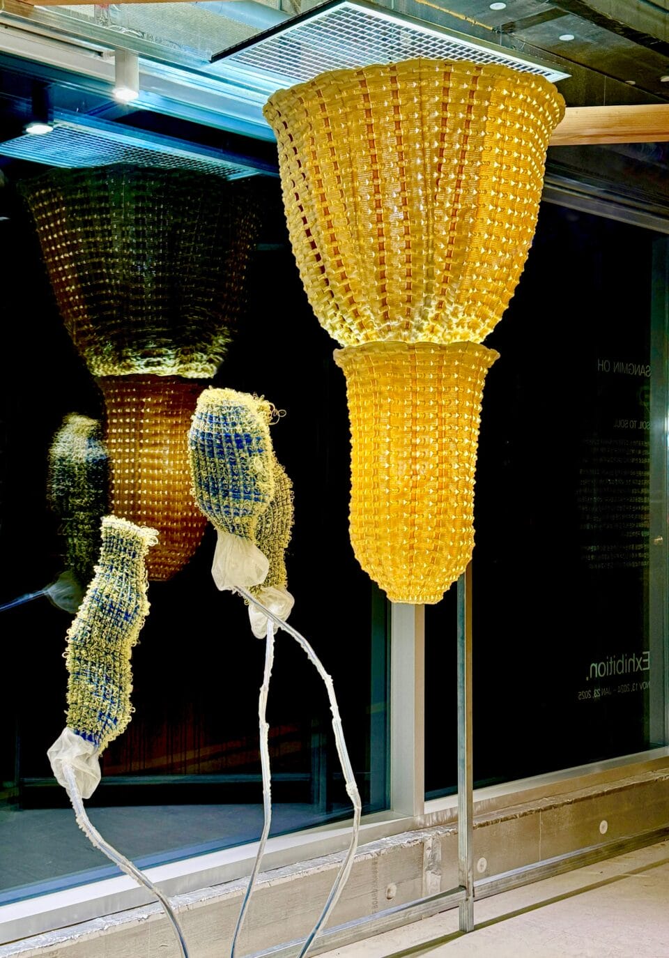 an installation of abstract lighting fixtures made from woven material