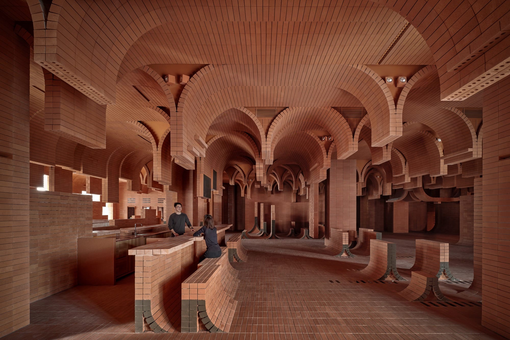 the interior of a cinema lobby made in a contemporary style with curved brickwork