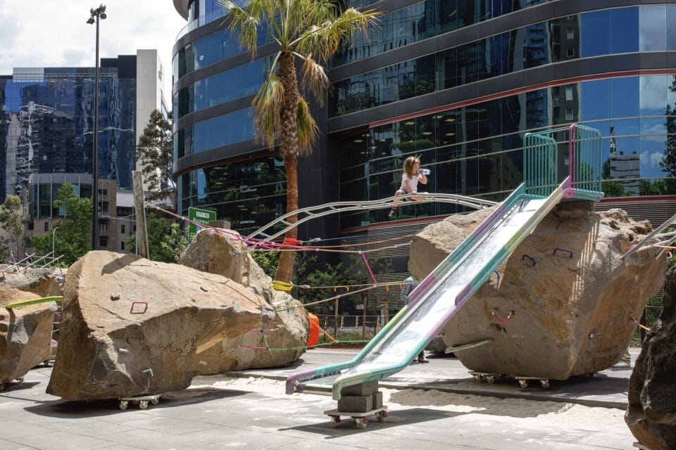 slides and monkey bars attach to massive boulders atop tiny wheels