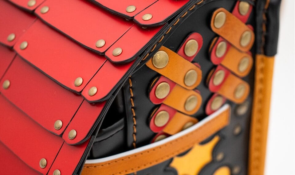 a detail of a backpack made from small strips of leather and brads to resemble samurai armor