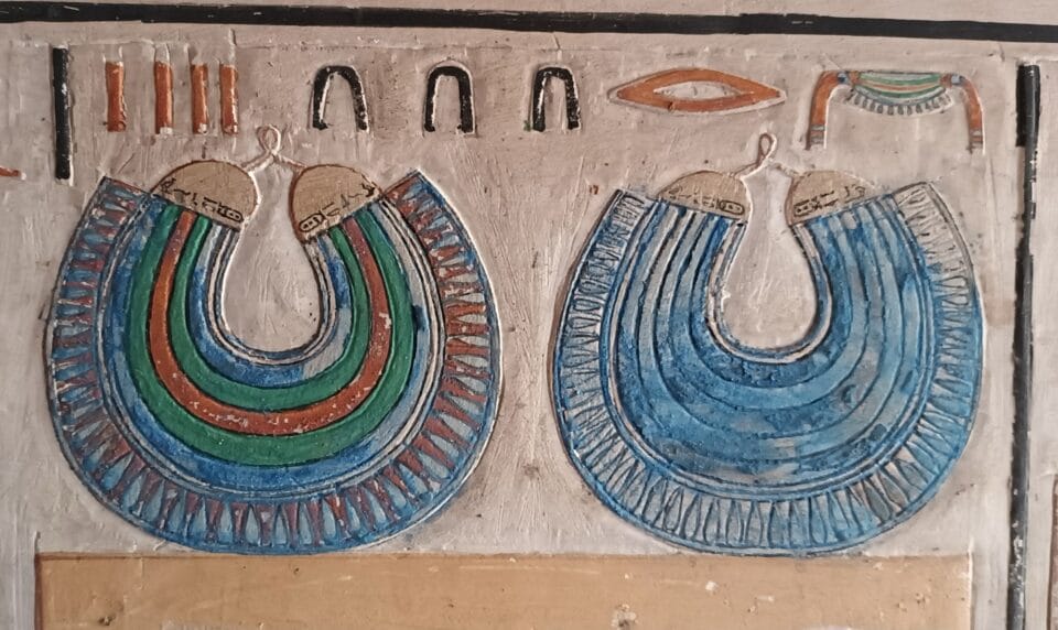 painted stone relief carvings of jewelry and garments in an ancient Egyptian tomb