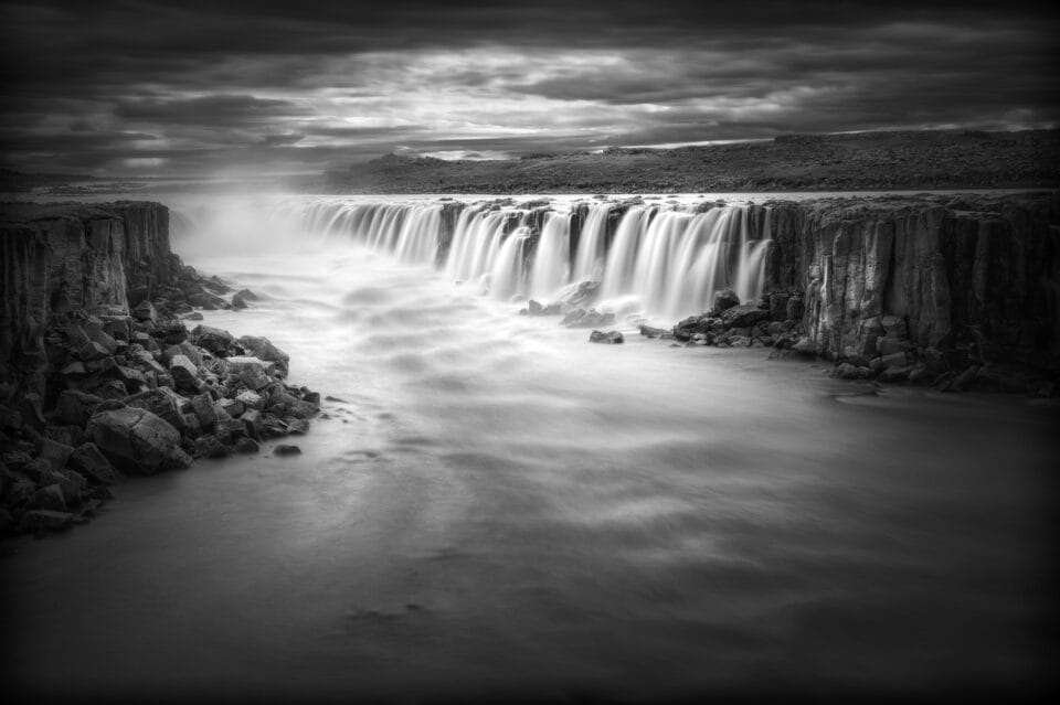 a black-and-white photograph of a waterfall in Iceland