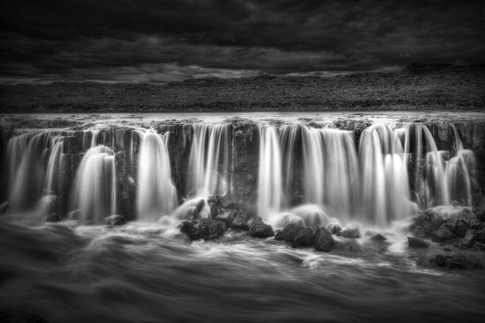 a black-and-white photograph of a waterfall in Iceland