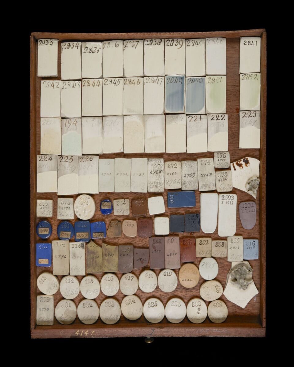 a tray of various shapes of ceramic pieces glazed with different colors